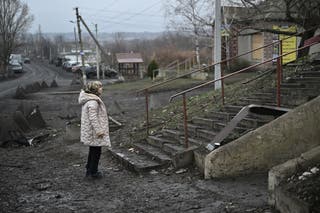 Svitlana Rudokvas stands next to a destroyed restaurant in the village of Novopavlivka